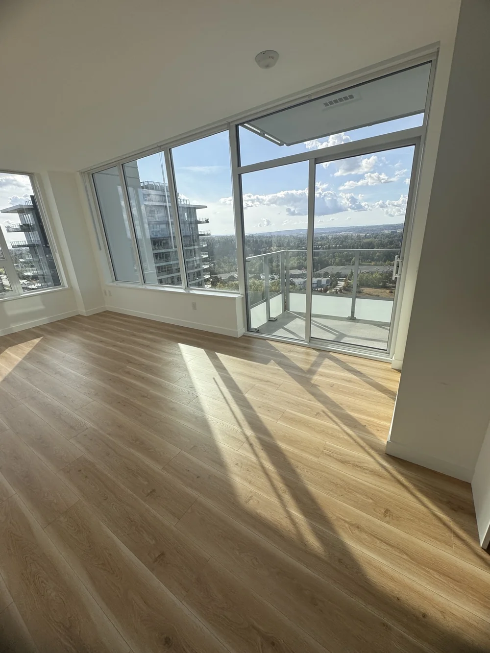 Empty, spotless living room with floor-to-ceiling windows after a move-out clean