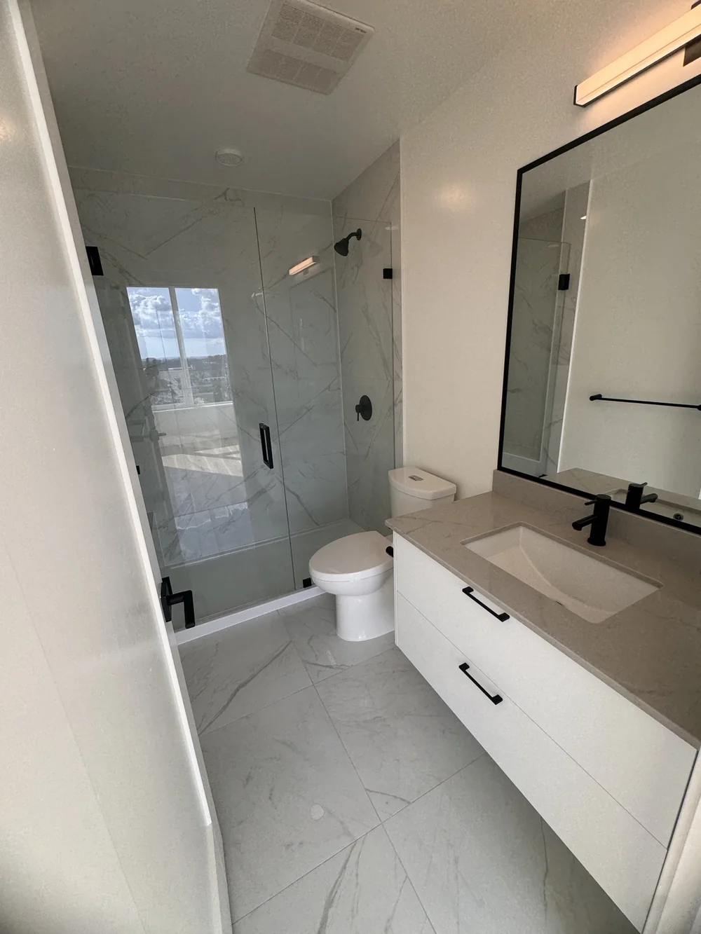 Marble bathroom with a glass shower, cleaned to a shine