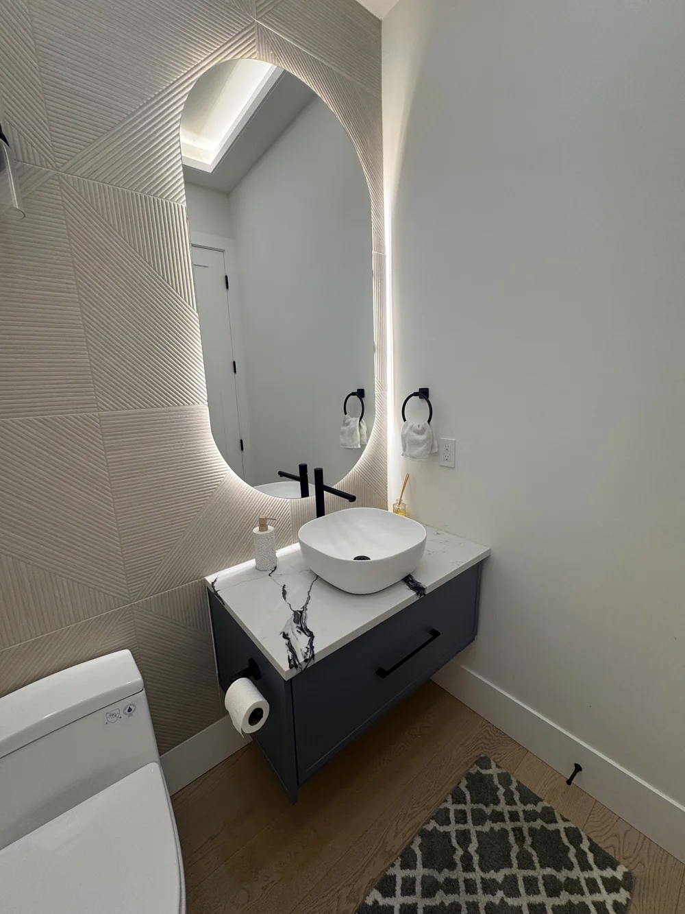 Elegant powder room with a backlit mirror after cleaning